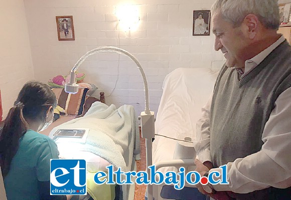 El alcalde Pedro Caballería observa a la funcionaria atendiendo a la paciente postrada en su propia casa, una gran innovación pionera en el valle de Aconcagua.