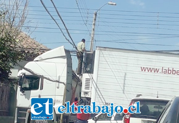 Acá vemos a un Carabinero levantando los cables para que pase el camión. Luego de solucionado el problema, el camión siguió su marcha. (Foto @aconcaguaradio)
