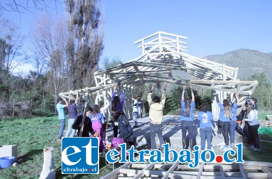 Una treintena de voluntarias y voluntarios de la Universidad Adolfo Ibáñez y de la Pastoral de la Universidad Católica de Santiago, se encuentran levantando el lugar de oración junto a la comunidad.