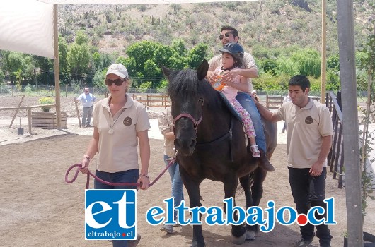 La pequeña Piera junto a su terapeuta sobre ‘Bernardita’, una de las yeguas destinadas a ‘monta gemela’, terapia que puede durar aproximadamente 30 minutos y que necesita además dos personas como apoyos laterales y un tirador del caballo.