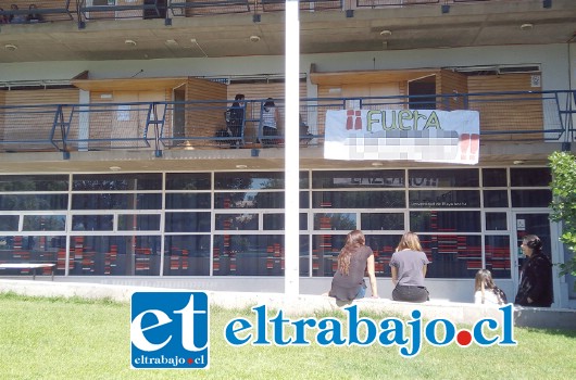 En el patio central del campus San Felipe de la Upla, pancartas piden la salida del docente.