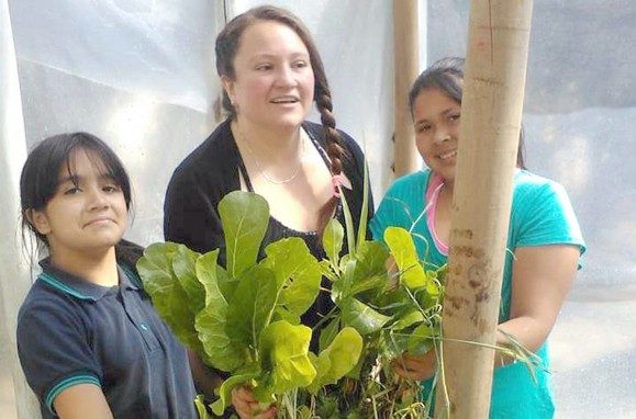 La profesora Romina Verdejo junto a alumnos durante la jornada de cosecha en la Escuela San Rafael.