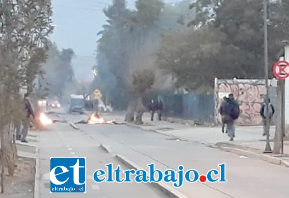 Neumáticos encendidos, en medio de la calle frente a la Upla, mientras Carabineros vigila el lugar.