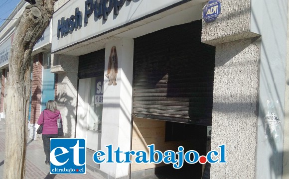 Cortina a medio abrir de la tienda de zapatos Hush Puppies ubicada en calle Salinas, a pasos de la plaza de armas.