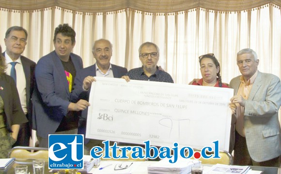 Alcalde y concejales entregando un gigantesco cheque a la institución de los ‘Caballeros del Fuego’.