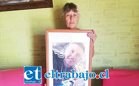 Acá vemos a Fresia Soto sosteniendo entre sus brazos un cuadro con la foto de su hijo.