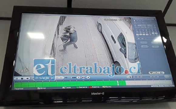 En la imagen captada por las cámaras de vigilancia del local, se aprecia al delincuente en plena faena intentando romper el vidrio de la mampara.