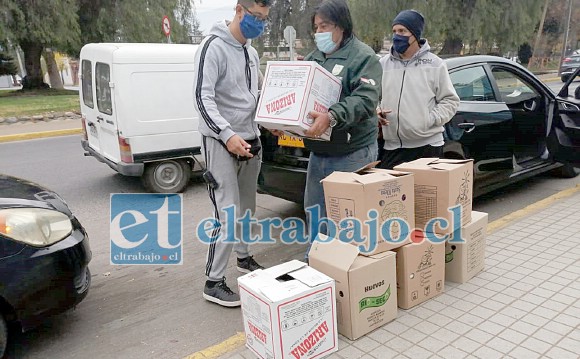 Juan Torrejón, presidente del Sindicato de Taxis Independiente entregando a uno de sus socios la caja con mercadería.