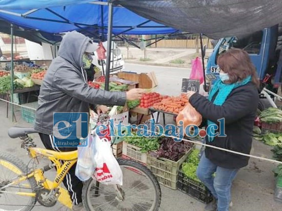 Una comerciante atendiendo a un cliente este domingo al reabrirse la feria.