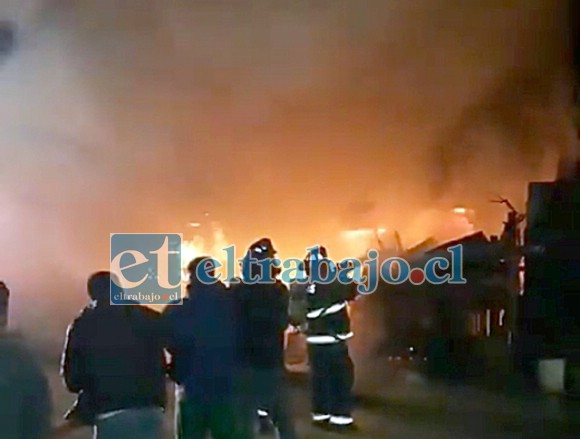 Bomberos junto a vecinos combatiendo juntos el incendio de las dos viviendas en el pasaje Eucaliptos de Villa 250 Años de San Felipe.