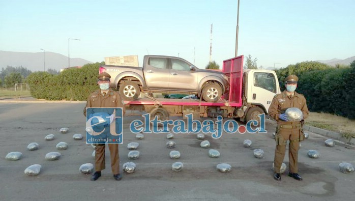 En la imagen personal de Carabineros sostiene la droga, atrás el camión y la camioneta donde se transportaba la marihuana elaborada.