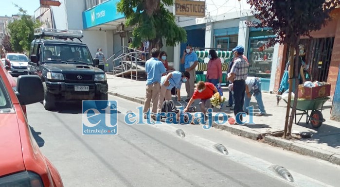 Inspectores municipales prestan auxilio a la adulta mayor que está tirada en el suelo.