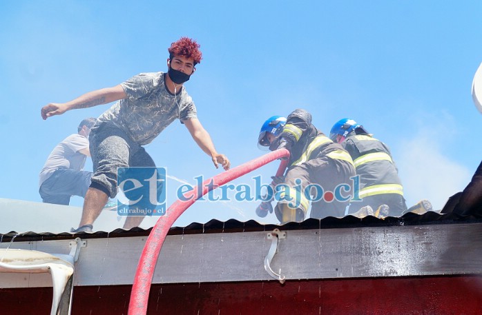 EN EL LUGAR.- Las cámaras de Diario El Trabajo captaron el justo momento cuando este vecino apoya a los bomberos en el techo.