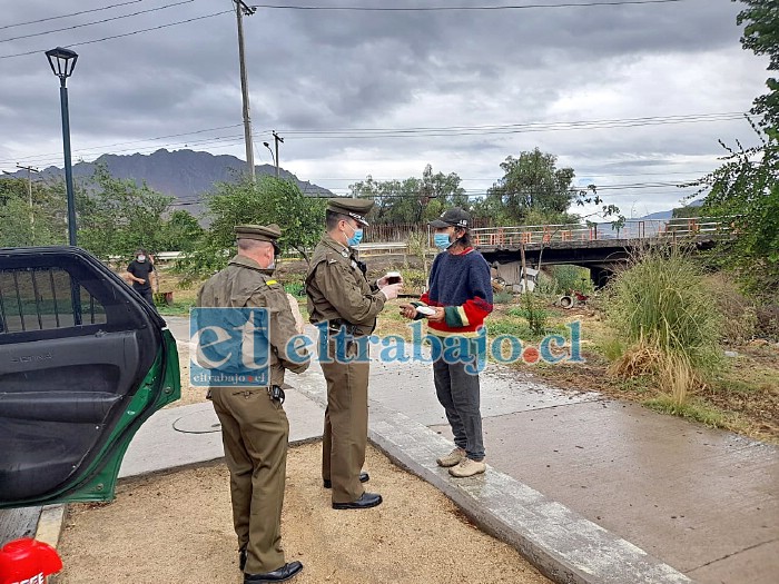 Carabineros entregando desayuno a un hombre en situación de calle, cerca del Puente Encón.