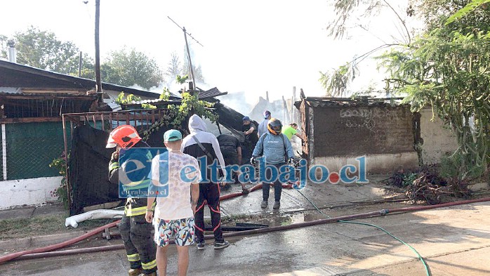 Personal de bomberos efectuando remojo una vez terminado el incendio que destruyó dos viviendas.