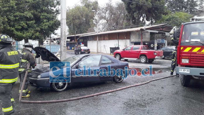 Personal de Bomberos de San Felipe tirando agua al motor para enfriarlo.