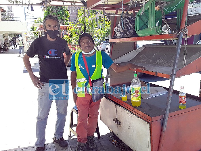 El afectado, Juan Domingo Rojas (a la izquierda), junto a su compañero de trabajo Luli, frente al carro donde estaba la bicicleta.