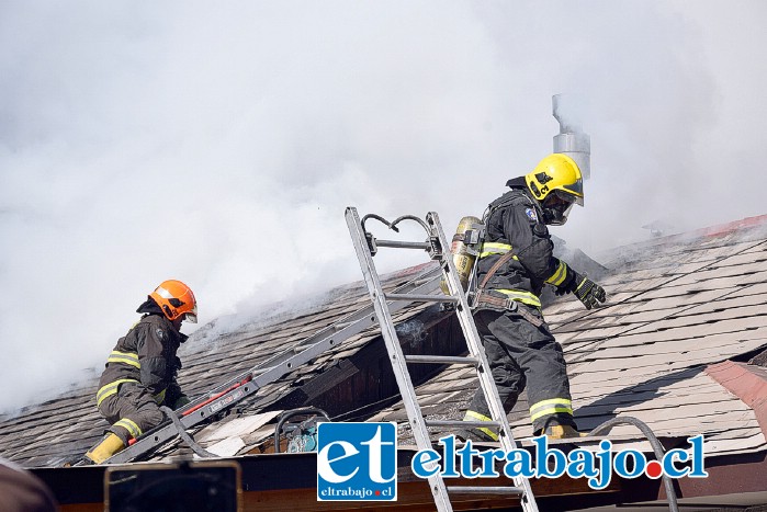 HÉROES EN ACCIÓN.- Los ‘Caballeros del Fuego’ debieron destechar la vivienda para controlar los focos calientes en el entretecho de la casa afectada.