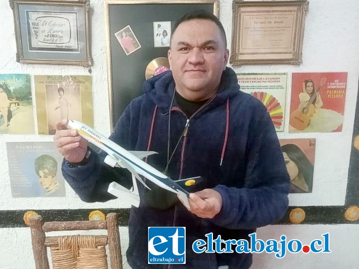 Ricardo Carlos Figueroa Cerda mostrando un avión de su colección en miniatura.