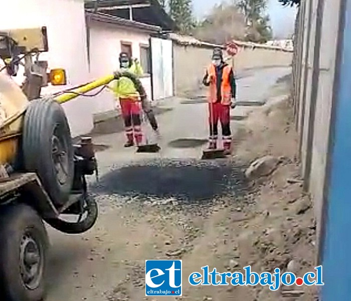 Trabajadores esparciendo asfalto sobre una calle en el sector El Asiento.