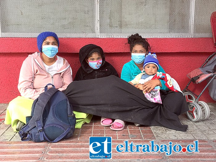 Lismery junto a su familia sentadas en el suelo, al costado de la municipalidad de San Felipe, pidiendo ayuda económica a la gente que pasa por el lugar.