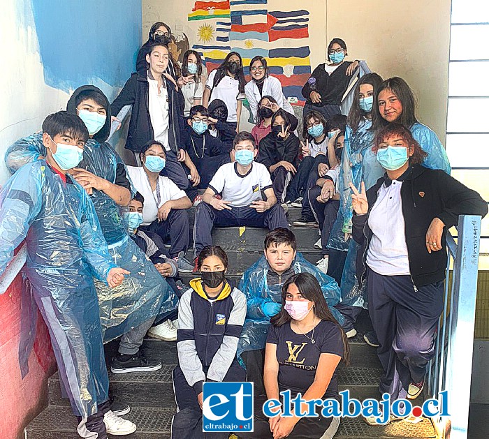 Alumnos y alumnas de sexto, séptimo y octavo básico, junto al mural que representa la unidad que los alumnos y la multiculturalidad que existe en el establecimiento.