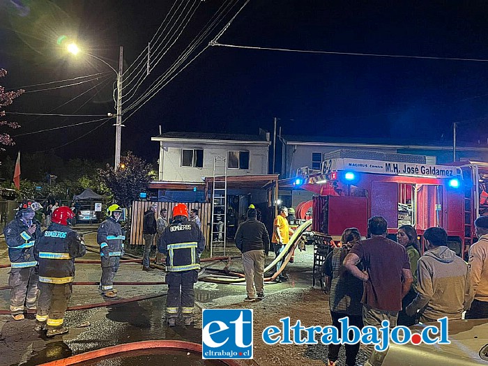 Bomberos y vecinos presentes en el lugar del incendio el jueves en la noche en Población Los Viñedos en Santa María.