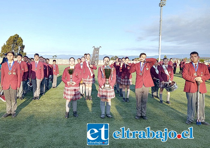 La banda del Colegio Alonso de Ercilla junto a algunos de los premios obtenidos, los que son sostenidos por Belén Saiz y Sakura Herrera.