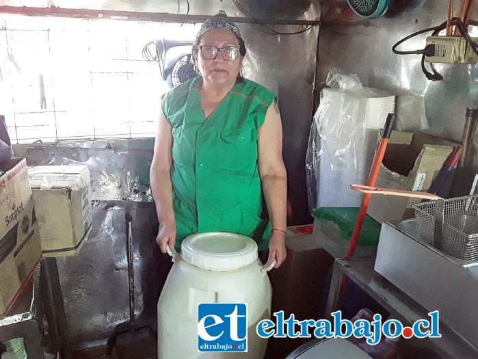 La ‘Tía Mabel’ junto al bidón donde deposita el aceite usado en su local para freír papas.