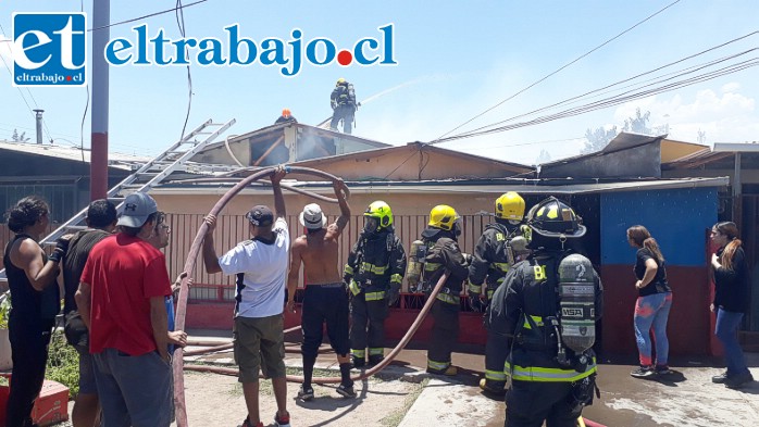 Vecinos ayudan a sostener una de las mangueras como una forma de colaborar con Bomberos.