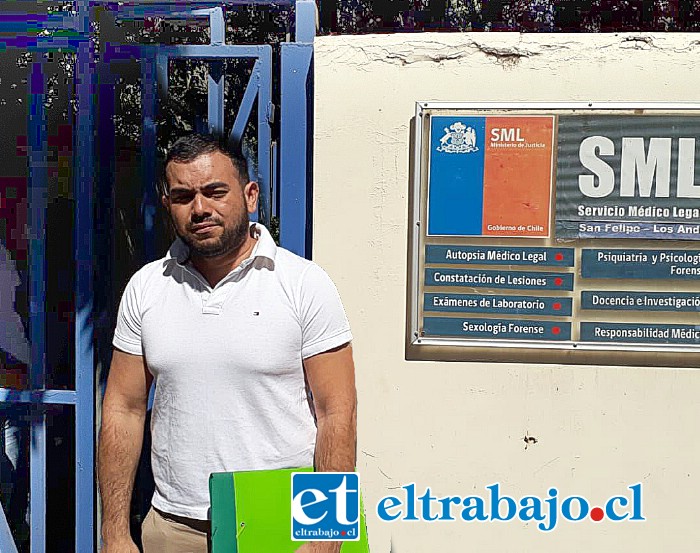 Juan, hermano de la madre del menor de un año diez meses, en las afueras del SML de San Felipe, esperando por el cuerpo del pequeño que, a una semana de su muerte, aún no pueden sepultar.