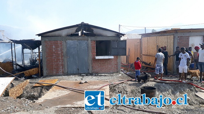 Una de las casa de material sólido que también resultó con daños. Dicen que ahí se vendía comida y bebida. Al lado un grupo de personas contemplando los daños.