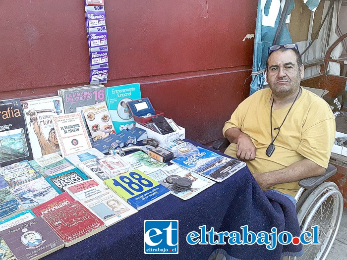 Guillermo ‘Willy’ Pérez junto a su silla de ruedas, triciclo y libros.