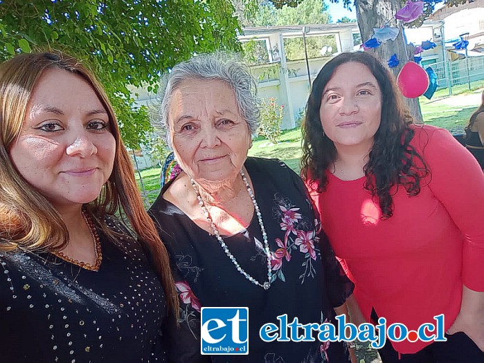 Al centro María Angélica González junto a dos mujeres cuidadoras.