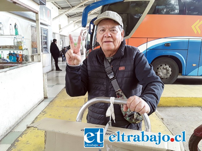 Don Armando Lavanderos, haciéndonos la V de la victoria apoyado en su carro.