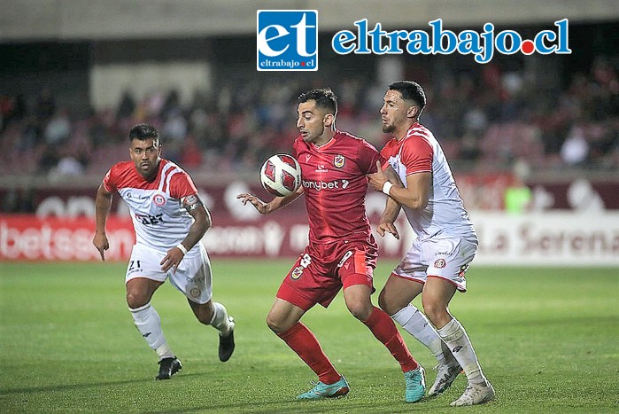 El zaguero central Ignacio Meza intenta sacarle el balón a un jugador granate.