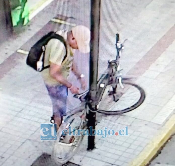 En la fotografía se aprecia cuando el antisocial provisto de algún elemento cortante, precisamente corta el seguro de la bicicleta. (Cedida por la hija).