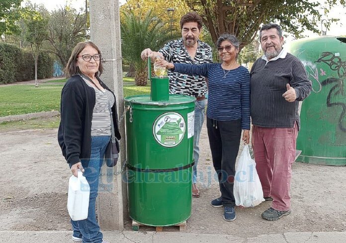 Vecinos depositando aceite en el tambor para que sea posteriormente retirado por la empresa.