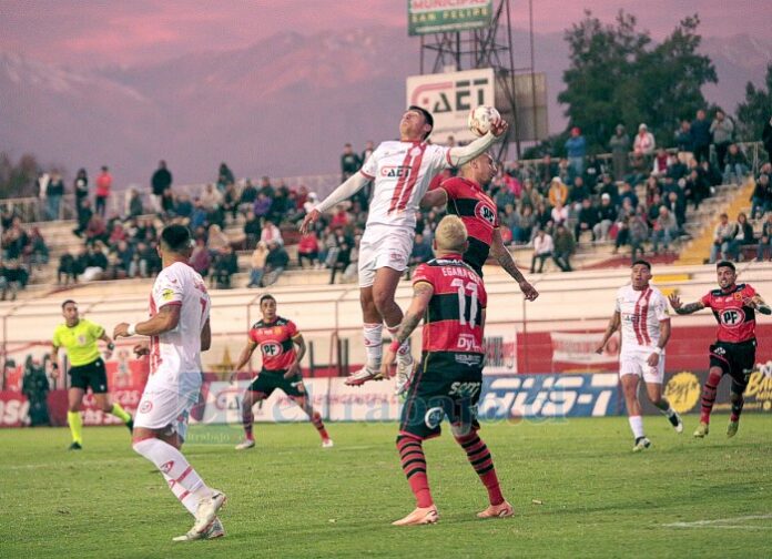 El volante Iván Vásquez disputa un balón aéreo con un zaguero talquino.