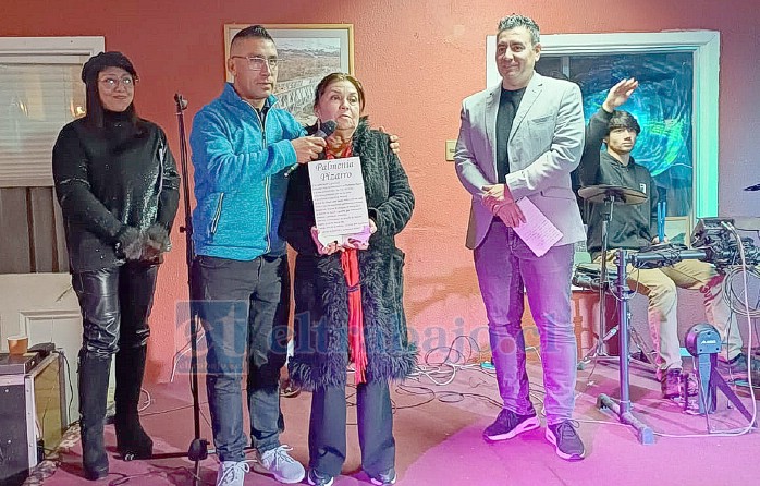 La hija de Palmenia Pizarro, Miriam, recibiendo el diploma de reconocimiento hacia su madre.