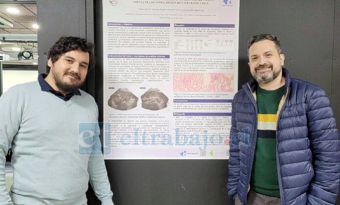 El doctor Osses junto al doctor Pablo Borrás en la XXIV reunión anual de la Sociedad Chilena de Patología Clínica Animal, la que reúne a los máximos exponentes de la disciplina médico veterinaria del país. En la foto, detrás de los veterinarios, está el poster ‘Diagnóstico de Hepatozoon canis en un perro vago de Los Andes, Región de Valparaíso, Chile’.