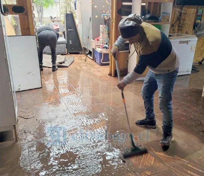Residentes de los principales sectores afectados limpiando su hogar tras el desborde del Estero Los Loros.