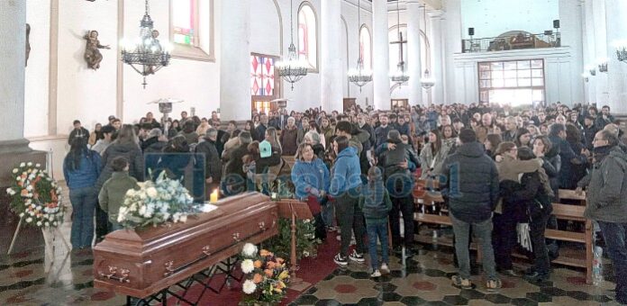 Los asistentes a la misa en el momento de la paz, en un lleno total del céntrico templo católico.