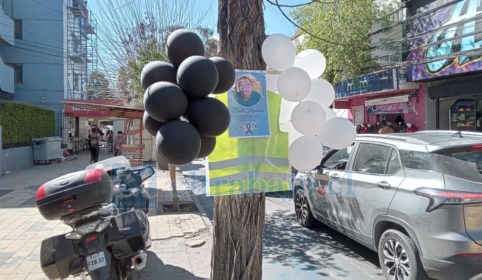 Globos blancos, negros con su foto en el árbol ubicado en el lugar donde se instalaba diariamente, ahí en calle Coimas, frente al Pasaje Juana Ross.