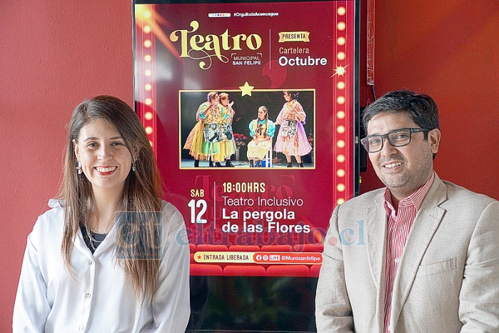 La coordinadora de la Oficina de la Discapacidad, Paulina Labarca, y el alcalde subrogante, Hernán Herrera, posan junto al cartel del musical inclusivo ‘La Pérgola de Las Flores’.