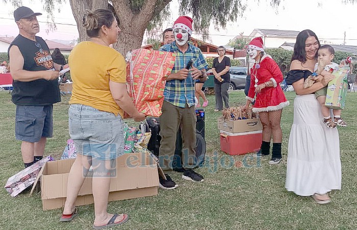 Una mamá contenta junto a su bebé después de recibir el regalo de Navidad.