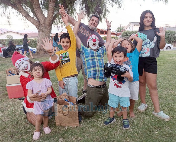 El presidente de la junta de vecinos, Jesús Chaparro, junto a los mimos, la ‘Viejita Pascuera’ y los niños felices con sus regalos.