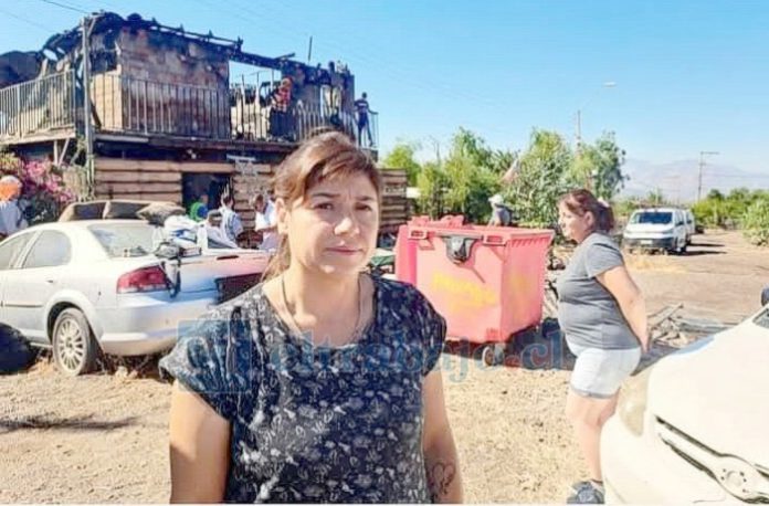 Margarita Bruna y al fondo se aprecia su casa destruida. (Foto Putaendo Informa).