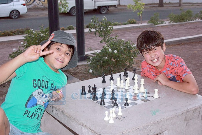 Dos alegres pequeños practicando el ajedrez.