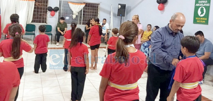 Rodrigo Llanos Collao, secretario del Club Marcela Sabaj, hace entrega de un reconocimiento a uno de los alumnos participantes del taller.